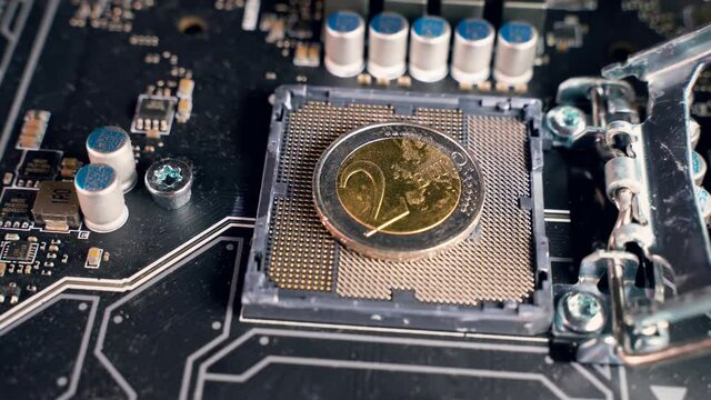 2 euro coin over a CPU slot in a motherboard, symbolizing the Digital Euro. European and the national central banks of the euro area are exploring the benefits and risks of a digital coin.