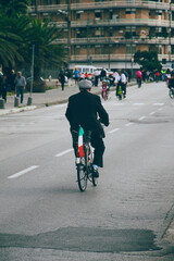 senior on bicycle with Italian flag