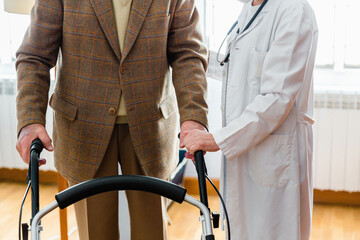 Nurse helping elderly man with a walker
