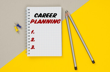 On a yellow-gray background are pencils, buttons and a notebook in which it is written - CAREER PLANNING