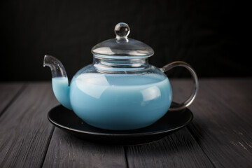 Blue anchan tea with milk in the glass teapot