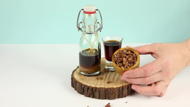 Propolis or bee glue is a resinous mixture that honey bees produce by mixing saliva and beeswax with exudate gathered from tree buds, sap flows or other botanical sources. Tincture in bottle.