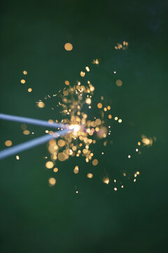 Close Up Of Two Joined Fourth Of July Sparklers Against A Green Background