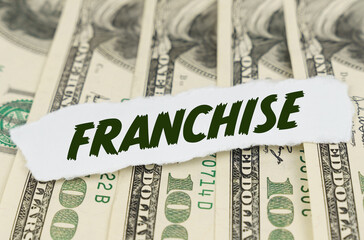 On the background of dollars lies a piece of paper with the text - FRANCHISE