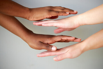 outstretched two female hands holding on top of each other, women keeping empty palm on gray isolated background. people diversity, help, support, love concept
