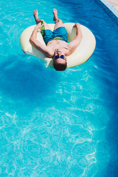 Man Sitting on a Round Ring in the Swimming Pool