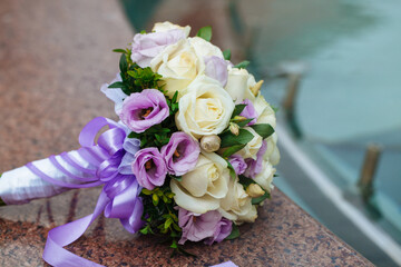 Beautiful wedding bouquet of natural flowers on a blurred background lies on granite