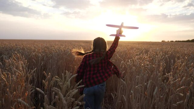 girl kid run with a toy airplane at sunset. kid dream childhood concept. girl child runs with an airplane toy silhouette in the park. carefree child dream outdoors silhouette. people fun in the park