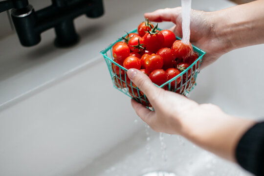 tomatoes being washed in a white sink