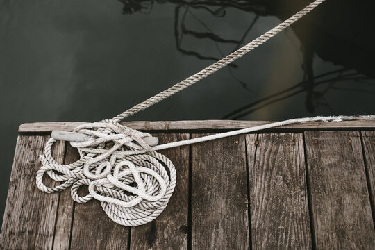 ropes tied down to dock by the water