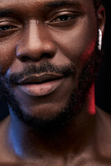 Obraz premium african young man in wireless headphones, looking at camera having nice smile, bearded man with dark skin