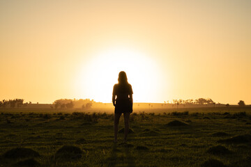 silhouette of a person standing in the sunset