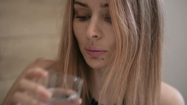 Attractive woman taking supplements pills and drink a glass of water