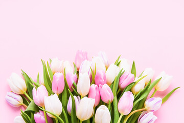 Obraz premium Pink and white tulips bouquet on a light pink background, selective focus. Flat lay, copy space