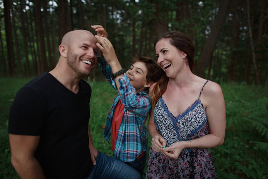 Happy family of three goofing around together outside in nature