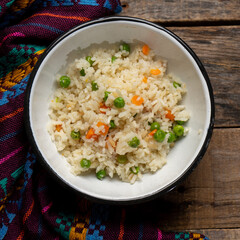 White rice with peas and carrot on wooden