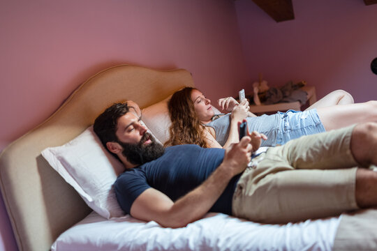 Couple in the bedroom holding cellphone