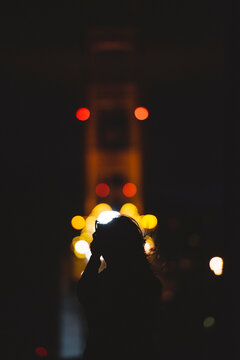 Woman Taking Picture Of Golden Gate Bridge At Night