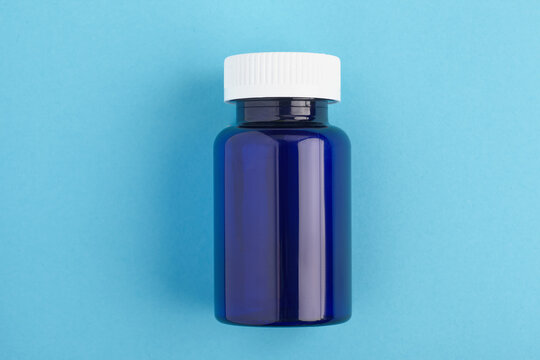 Pills package, Close up pill bottle on blue background. Medicine, medical insurance or pharmacy concept close up with copy space.