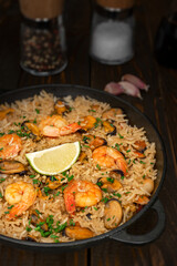 Spanish paella with shellfish and prawns on wooden table