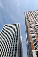 High bottom up perspective view of modern city skyscraper buildings with many windows in the urban cluster