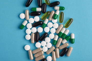 Closeup of white pils and colorful capsules. Heap of pills - medical background