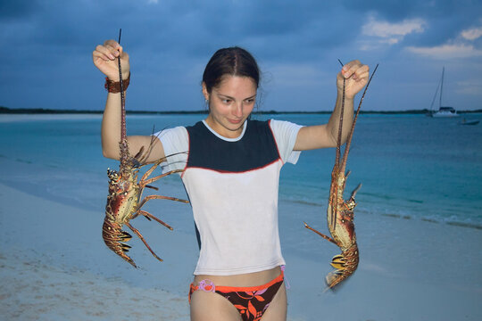 Young woman holding two alive crayfish