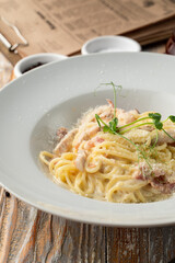 Classic carbonara spaghetti with grated parmesan close up, juicy yummy shot