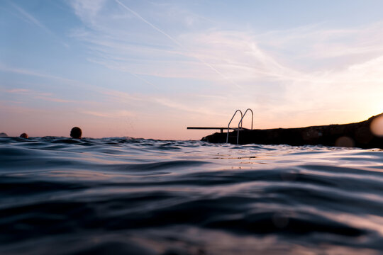 Unrecognizable people jumping from sea floating platform