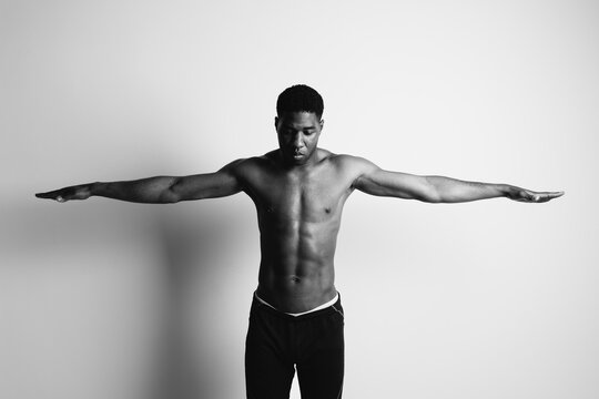 Muscular topless man with outstretched arms