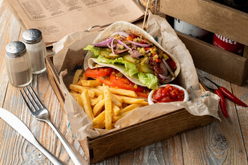 Mouth Watering big portion of gyros with shredded meat, vegetables and fries, appetizing photo for a magazine