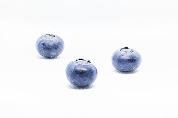 3 isolated blueberries seen from the front on a white background.