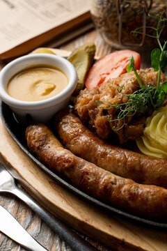 Appetizing roasted german wursts with spicy mustard and fluffy mashed potato, german pub photo