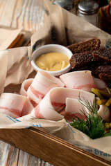 Spicy and salty pork fat with rye croutons and spicy mustard, close up, appetizing photo of a...