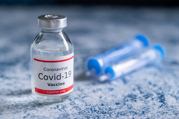 A single bottle vial of Covid-19 vaccine. Medical concept vaccination hypodermic injection...