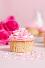 homemade vanilla cupcakes with pink buttercream frosting and heart sprinkles 