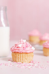 homemade vanilla cupcakes with pink buttercream frosting and heart sprinkles 