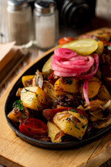 Close up of potato and meat stew with herbs and onion in a cast-iron, comfort food