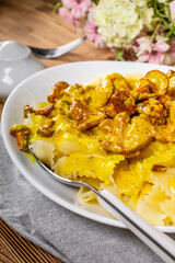 Pasta with fried chicken in cream and chanterelle sauce.