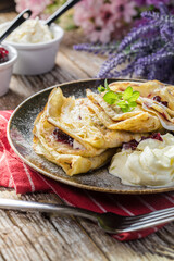 Crepes with ricotta cheese and blackcurrant jam.