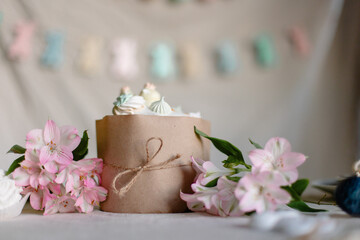 Cute beautiful Easter cake on a decorated table. Religious traditional Christian food. Orthodox Easter kulich with glaze and meringue. Still life.  homemade russian pastries. flowers background 