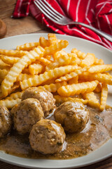 Meatballs with french fries in dill sauce.