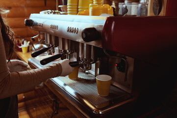 Closeup of unrecognizable barista making coffee in professional coffee machine