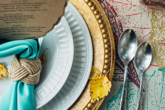 Plates, napking and sloon at a fall-themed table