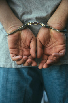 Man in handcuffs next to his car