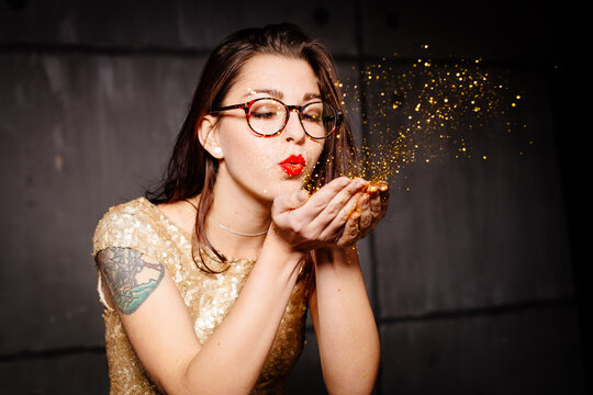 Girl blowing glitters out of hands