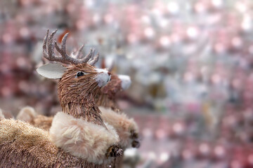 Toy deer with shining antlers, copy space holiday card, pink shining highlights