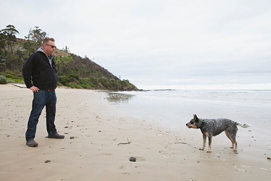 Middle aged man with his dog on the beach at Wye River