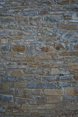 Stone wall of natural stones in different sizes; Rustic stone veneer in shades of brown and beige