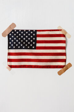 A vintage American flag held to wall with band aids